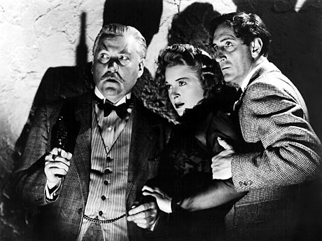 De g. à d. : Nigel Bruce, Evelyn Ankers et Basil Rathbone, dans La Voix de la terreur (1942, photo promotionnelle)