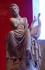 Statue d'une femme assise vue de face, un drapé sur les jambes et une lyre sur sa gauche.
