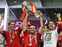 Spanish footballers Fernando Torres, Juan Mata, and Sergio Ramos celebrating winning the UEFA European Championship in 2012 Torres, Mata and Ramos Euro 2012 trophy 01.jpg