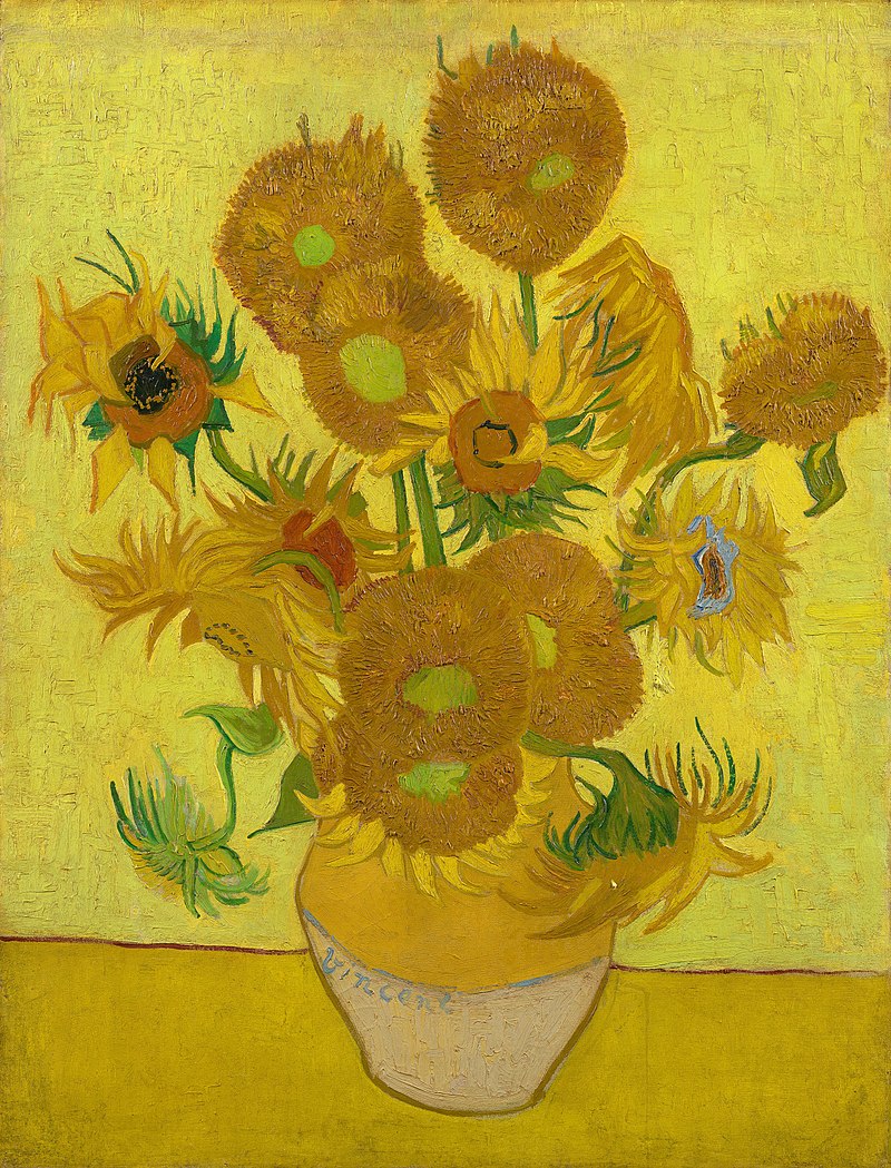 A ceramic vase with sunflowers on a yellow surface against a bright yellow background.