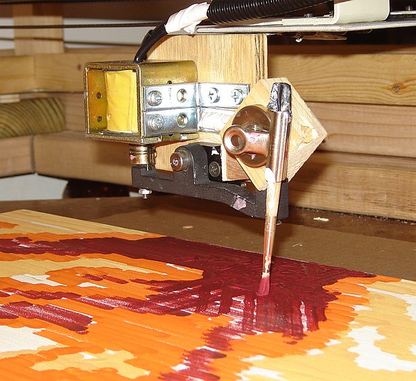 A robotic brush head painting on a canvas