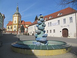 Masarykovo náměstí s kašnou, muzeem a kostelem Nanebevzetí Panny Marie