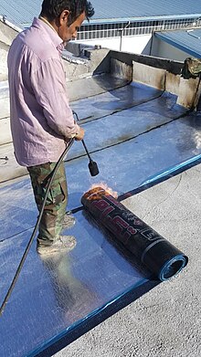 Torch-on bitumen-based waterproofing membrane being rolled out. Tehran Iran nSb yzwgm.jpg