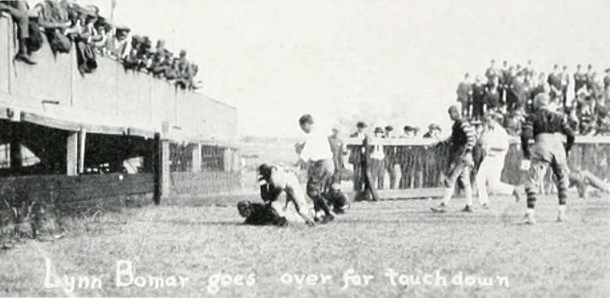 Touchdown photographed from the side， with fans in an end-zone grandstand