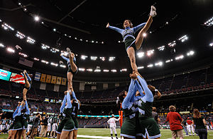 Several women held in the air kicking with men below them