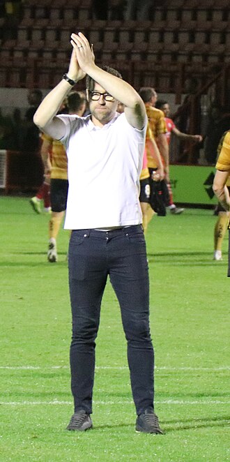 Artell applauds Crewe's travelling supporters at the end of an away win at Crawley Town.