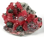 Rhodochrosite with fluorite, tetrahedrite and quartz; the tetrahedrite occurs as sharp, metallic crystals