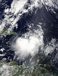 Tormenta tropical Karen el 24 de septiembre de 2019. Se puede ver tierra por encima y por debajo de la tormenta.  La tormenta es ligeramente asimétrica.