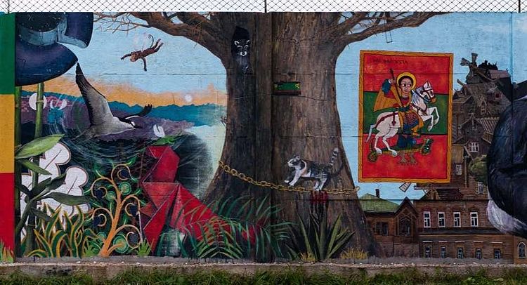 Large, colorful wall painting of a tree, animals and a religious icon