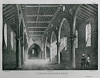 Inside of a large, vaulted stone building, with two rows of archways down the middle