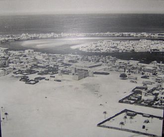 Dubai in 1950; the area in this photo shows Bur Dubai in the foreground (centered on Al-Fahidi Fort); Deira in middle-right on the other side of the creek; and Al Shindagha (left) and Al Ras (right) in the background across the creek again from Deira Mid-20th century Dubai.JPG