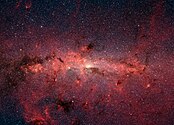 Le centre de la Voie lactée, vu en infrarouge par le télescope spatial Spitzer de la NASA. Dans cette zone des centaines de milliers d’étoiles gravitent autour du centre galactique. En lumière visible, cette région n’est pas visible car elle est cachée par une grande quantité de poussière interstellaire. (définition réelle 3 501 × 2 525)