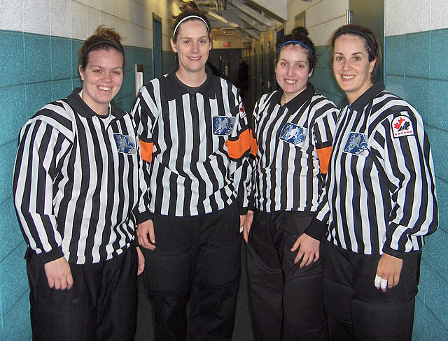 These officials are working in a four-official system; the two middle officials are the referees, identifiable by their orange armbands