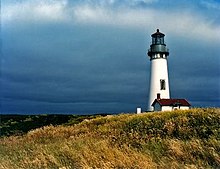 Yaquina Head Lighthouse (Oregon);  det lille hvite huset med et tynt fyr ser ut som det begynner.