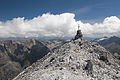 Gipfelkreuz des Piz Pisoc. Am rechten Bildrand, in ca. 11 km Entfernung, der Piz Sesvenna an der italienischen Grenze.