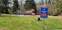 Playground in Port Moody, British Columbia, closed off with caution tape. A sign indicates the playground is closed because of COVID-19. Port Moody, BC - playground closed with COVID-19 signage.jpg