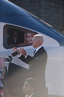 President Joe Biden during his visit to the B&P Tunnel in January 2023. An Avelia Liberty high-speed train is in the background. Presidential Visit to the B&P Tunnel (52660381428).jpg