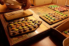 Swedish gingerbread house being prepared. Glaze is put on the walls. Putting glaze on gingerbread house for candy decorations.jpg