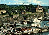 Gammelt postkort med Rådhusbryggene sett mot Akershus festning med utstikker A og B og nordre Akershuskai. Foto: Oslo byarkiv