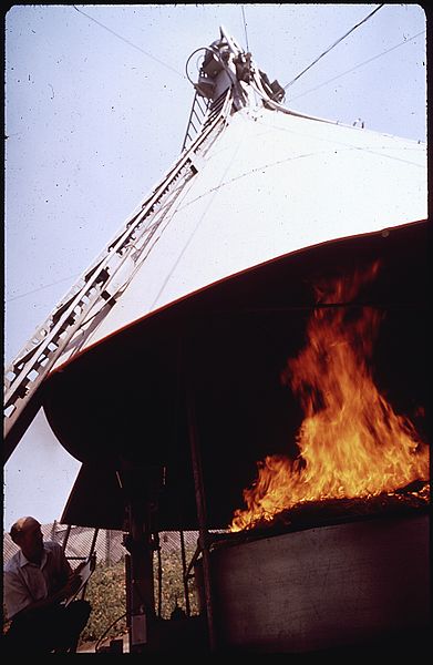 File:RESEARCH ASSOCIATE ERV MATEER OBSERVES THE BURNING OF WHEAT STRAW IN AGRICULTURAL BURNING TOWER, THE PURPOSE IS TO... - NARA - 542658.jpg