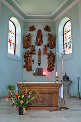 Chœur avec autel, sculptures et fonts baptismaux