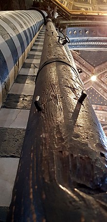 One of the two 18 m (60 ft) tall flagpoles in the Siena Cathedral. During the battle of Montaperti (1260), Bocca degli Abati, a Sienese spy, brought the Florence flag down causing panic among the Florentine soldiers and ultimately their defeat. SienaFlagpole1.jpg