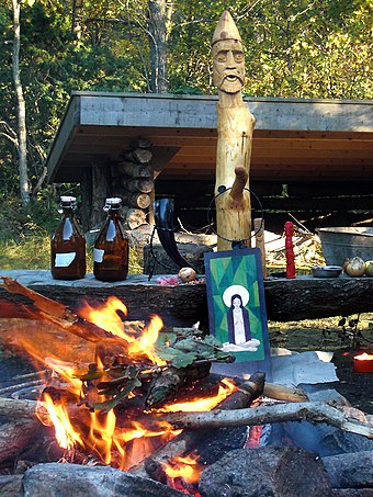 Altar for Haustblót in Bohus-Björkö, Västergötland, Sweden. The big wooden idol represents the god Frey, the smaller one next to it represents Freyja, the picture in front of it Sunna, and the small red idol Thor.