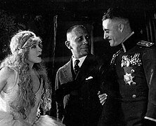 The Merry Widow (1925 film), directed by Erich von Stroheim, M-G-M studios. On set L to R, Mae Murray, von Stroheim, John Gilbert.jpg