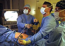 Surgeons perform a laparoscopic appendectomy. US Navy 060227-N-9742R-004 The Ship's Surgeon Lt. Cmdr. Michael Barker, center, and Senior Medical Officer Commander David Gibson, left, perform an urgent laparoscopic appendectomy.jpg