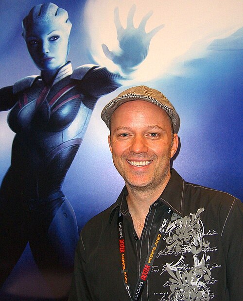 Writer Mac Walters in front of a Mass Effect poster at the Dark Horse Comics booth at the 2011 New York Comic Con