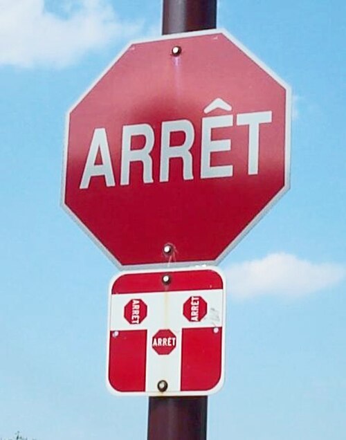 The "arrêt" signs (French for "stop") are used in the province of Québec, Canada while the English stop, which is also a valid French word, is used in