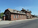 Entreegebouw van het treinstation van Beeskow met een treinstationrestaurant en goederenloods evenals twee bijgebouwen en een waterkraan