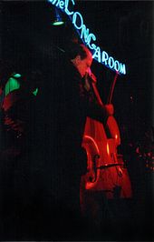 A man in a black suit holding a contrabass.