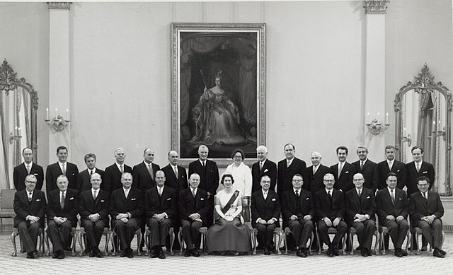 Elizabeth II, Queen of Canada, with her Cabinet, chaired by Prime Minister Lester B. Pearson, part of the 19th Canadian Ministry (Elizabeth's third), 