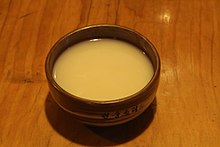 Beige, opaque liquid in a bowl on a brown table