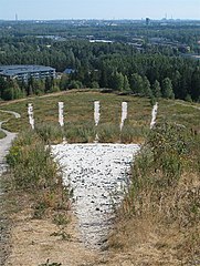 An arrow pointing towards the top of the Malminkartanonhuippu hill in Helsinki, Finland.