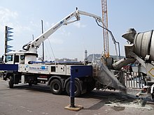 Beton wird von einem Fahrmischer in eine Autobetonpumpe befördert