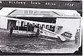 Reproduction of a photograph of a Royal Flying Corps Curtiss JN-4 aircraft C129 with "To Hell with the Kaiser" drawn on the side, outside a hangar building. The caption on the back of the photograph (3722660778).jpg