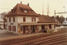 Fahrwangen-Meisterschwanden railway station in 1983 (closed in 1997) SBB Historic - F 122 00364 002 - Fahrwangen-Meisterschwanden WM Stationsgebaeude mit Gueterschuppen Bahnseite.jpg
