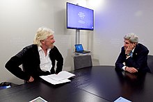 Branson discusses climate change with the United States Secretary of State John Kerry in 2016. Secretary Kerry Sits With Sir Richard Branson for a Discussion on Climate Change in Davos (24413230022).jpg