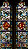 Dvoubarevné vitráže zachycující Alfu a Omegu