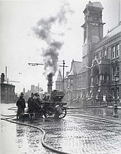 A steam pump truck in use in 1913, St Helens enabling fire-fighters to reach the burning clock tower. The limber for attaching to a horse team is visible stretching to the right. Steam Pump Truck for Firefighting StHelens1913.jpg