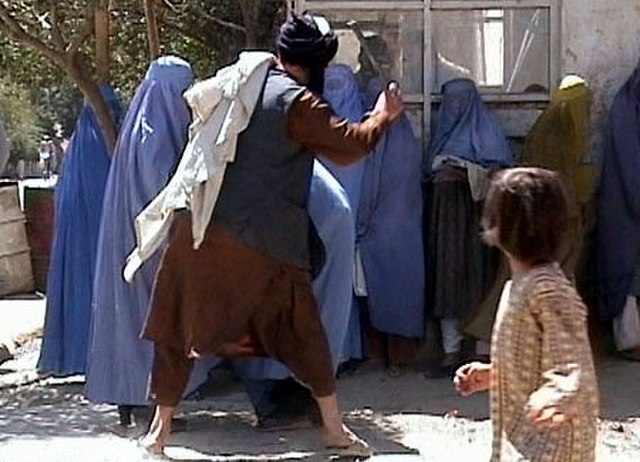 A member of the Taliban's religious police beating a woman in Kabul on 26 August 2001. The footage was filmed by RAWA.