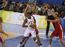 Lisa Leslie, dos au panier et la ballon dans les mains, avec une adversaire derrière elle, les mains en l'air.