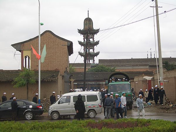 Worshippers leaving a small mosque in Linxia City, on foot, by truck and bus