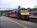 English: A British electric locomotive class 90 leaves Coventry propelling a West Coast service. Deutsch: Eine britische Elektrolokomotive der Baureihe 90 schiebt einen Zug der West Coast Line aus dem Bahnhof von Coventry.