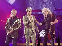 «Queen + Адам Ламберт» на концерті в Сан-Хосе у 2014 році. Зліва-направо: Роджер Тейлор, Адам Ламберт, Браян Мей