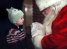 A young boy looks at Santa Claus