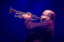 "Foto de Reinaldo Melián tocando trompete com as bochechas inchadas."