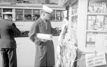 A sailor buys in a newspaper kiosk of Rosemont district